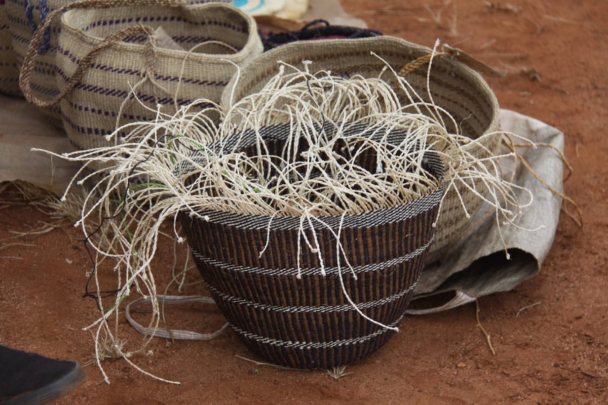 A vessel being woven from rods intertwined with jute, in Kenya